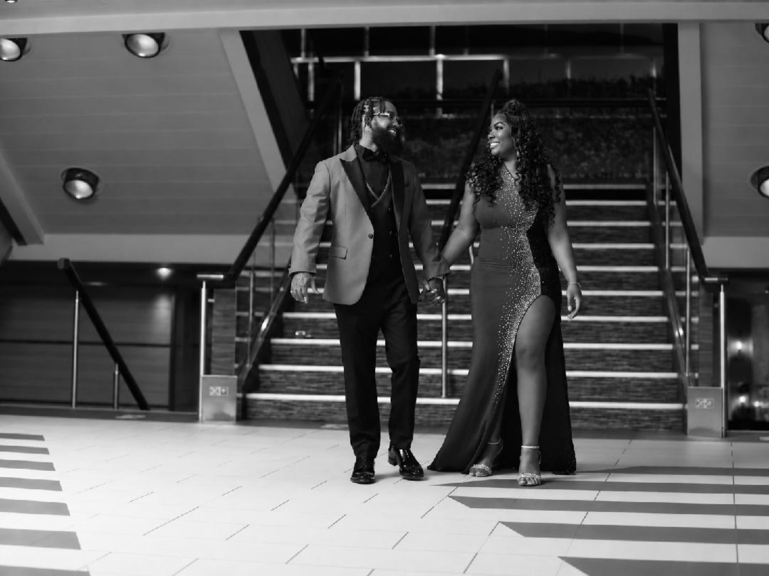 Kevin and Juanita holding hands in front of a grand staircase